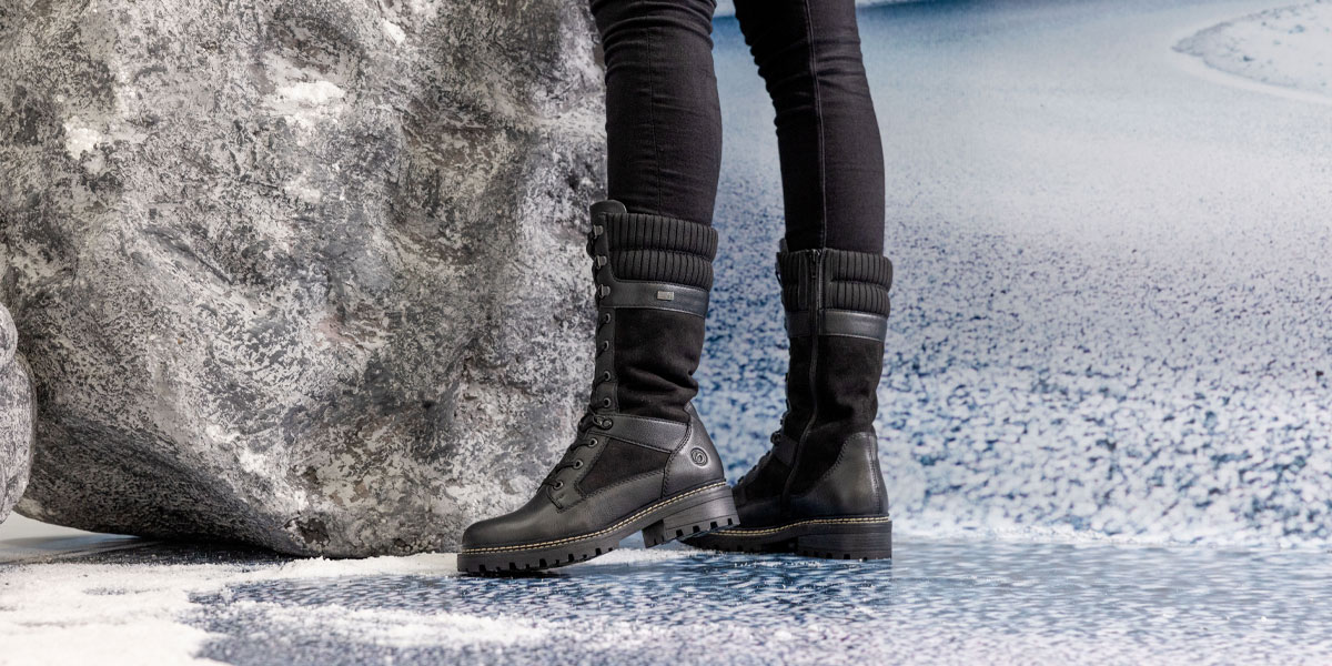 Best Mid Calf Boots: Pair of legs wearing mid calf boots in front of a snowy background